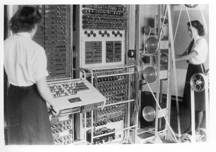 two female code breakers with large computers working to crack the enigma machine code
